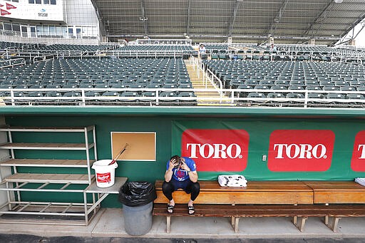 Minnesota Twins catcher Mitch Garver talks on his phone in an empty Hammond Stadium, Thursday, March 12, 2020, in Fort Myers, Fla. Major League Baseball has suspended the rest of its spring training game schedule because if the coronavirus outbreak. The league is also delaying the start of its regular season by at least two weeks. (AP Photo/Elise Amendola)