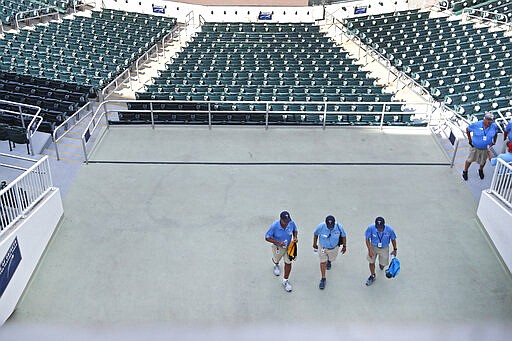 Ushers leave empty Hammond Stadium, after a baseball game between the Minnesota Twins and the Baltimore Orioles was canceled, Thursday, March 12, 2020, in Fort Myers, Fla. Major League Baseball has suspended the rest of its spring training game schedule because if the coronavirus outbreak. MLB is also delaying the start of its regular season by at least two weeks. (AP Photo/Elise Amendola)