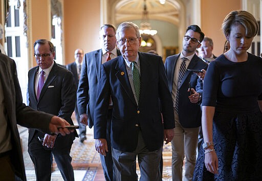 Senate Majority Leader Mitch McConnell, R-Ky., walks through a crowd of reporters after announcing he has canceled the Senate recess next week, at the Capitol in Washington, Thursday, March 12, 2020. (AP Photo/J. Scott Applewhite)