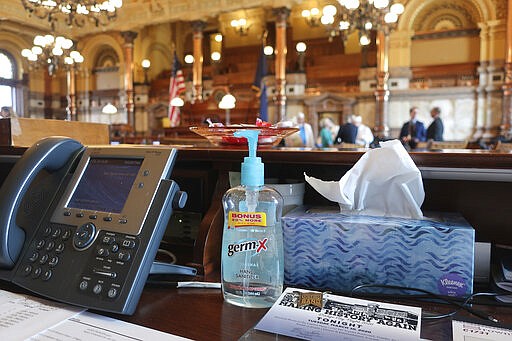 A bottle of hand sanitizer sits on the Kansas Senate sergeant at arms' desk in the back of the chamber, Thursday, March 12, 2020, at the Statehouse in Topeka, Kan. Kansas legislators are pondering whether they should take their annual spring break early because of the new coronavirus. (AP Photo/John Hanna)