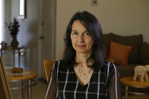 In this March 6, 2020 photo, Cioly Zambrano poses for a photo in her home in Orlando, Florida. Zambrano, is one of 32 jurists named to the Supreme Court by opposition leader Juan Guaido, immediately converting her and her family into high-priority targets for arrest. (AP Photo/Cody Jackson)