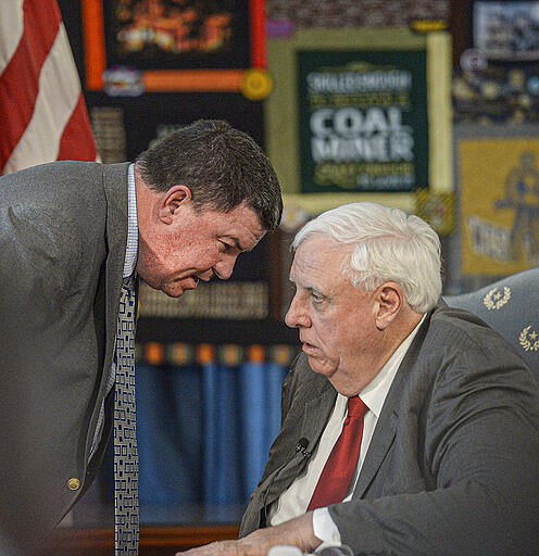 Bernie Dolan, left, executive director of the WVSSAC, speaks with West Virginia Governor Jim Justice, right, during a Thursday March 12, 2020 press conference at the West Virginia State Capitol in Charleston, WV. Governor Justice announced that the West Virginia Girls and Boys state basketball tournament will be canceled due to COVID-19. (F. Brian Ferguson/Charleston Gazette-Mail via AP)
