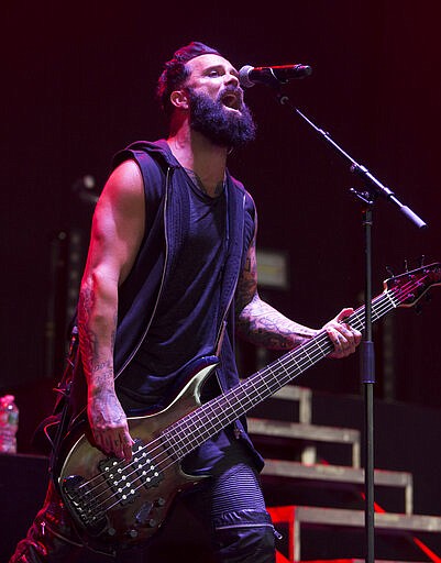 FILE - In this July 26, 2017 file photo, John Cooper of the band Skillet performs during their &quot;The Serenity of Summer Tour&quot; in Camden, N.J. More and more performers are changing live concerts plans because of the new coronavirus, which has forced Mariah Carey, BTS, Pearl Jam and even the Coachella festival to postpone dates. Skillet is performing the last several dates on their current tour, with shows in New York and Virginia taking place this week. Despite the spread of the virus, Cooper said he and his bandmates are still holding meet-and-greets with concertgoers. (Photo by Owen Sweeney/Invision/AP, File)