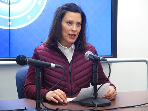 FILE - In this Tuesday, March 10, 2020, file photo, Michigan Gov. Gretchen Whitmer announces the state's first two cases of coronavirus, at the Michigan State Police headquarters in Windsor Township, Mich. Coronavirus cases in Michigan rose sharply late Thursday, March 12, 2020, as officials announced more cases, and as some K-12 schools began announcing closures while others began training staff to potentially move to online learning only. (AP Photo/David Eggert, File)