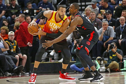 Toronto Raptors center Serge Ibaka (9) guards against Utah Jazz center Rudy Gobert (27) in the first half during an NBA basketball game Monday, March 9, 2020, in Salt Lake City. (AP Photo/Rick Bowmer)