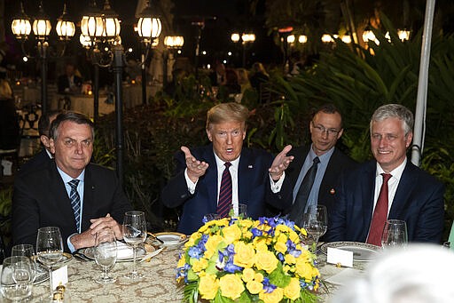 President Donald Trump speaks before a dinner with National Security Adviser Robert O'Brien, right, and Brazilian President Jair Bolsonaro, left, at Mar-a-Lago, Saturday, March 7, 2020, in Palm Beach, Fla. (AP Photo/Alex Brandon)