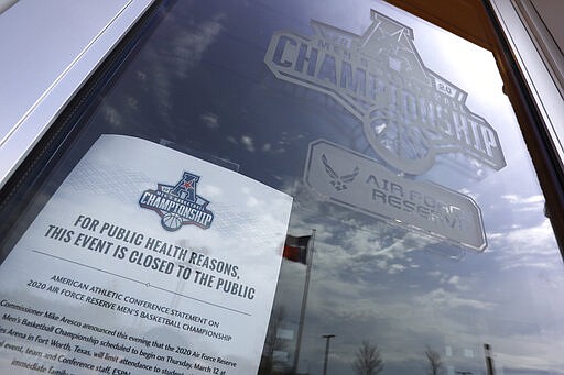 A sign posted at an entrance to Dickies Arena where the NCAA college basketball games in the American Athletic Conference tournament were to be played Thursday, March 12, 2020 in Fort Worth, Texas. The tournament was canceled due to coronavirus concerns. (AP Photo/Richard Rodriguez)