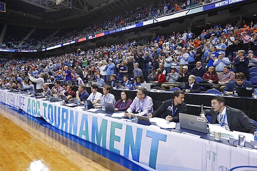 Fans and media watch during an NCAA college basketball game between North Carolina and Syracuse at the Atlantic Coast Conference tournament in Greensboro, N.C., Wednesday, March 11, 2020. The ACC announced it will close the remainder of its men's basketball tournament to spectators, beginning with Thursday's quarterfinals, amid the emerging threat of the spread of the coronavirus. (AP Photo/Gerry Broome)