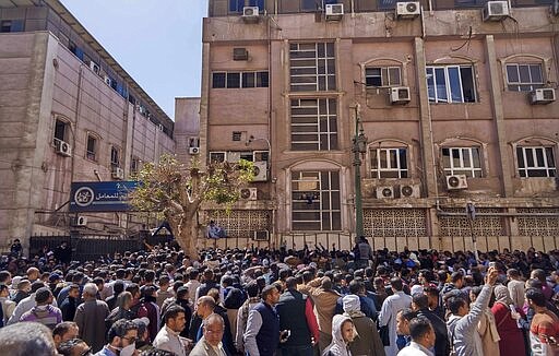 Egyptians who are traveling abroad in the next 24 hours wait for their turn to get a coronavirus test, in front of the Central Public Health Laboratories, that belongs to the Egyptian Health Ministry, in Sheikh Rihan street, downtown Cairo, Egypt, Sunday, March 8, 2020. (AP Photo/Hamada Elrasam)