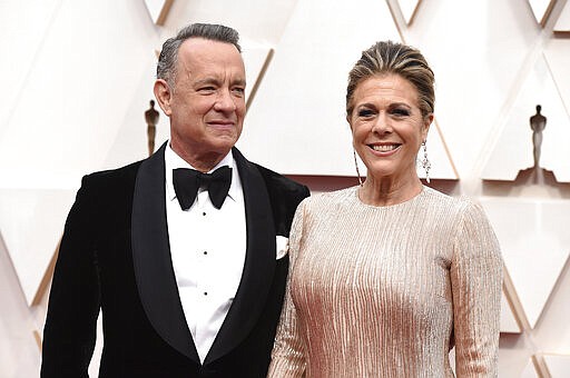 FILE - In this Feb. 9, 2020 file photo, Tom Hanks, left, and Rita Wilson arrive at the Oscars at the Dolby Theatre in Los Angeles. The couple have tested positive for the coronavirus, the actor said in a statement Wednesday, March 11. The 63-year-old actor said they will be &quot;tested, observed and isolated for as long as public health and safety requires.&quot; (Photo by Jordan Strauss/Invision/AP, File)