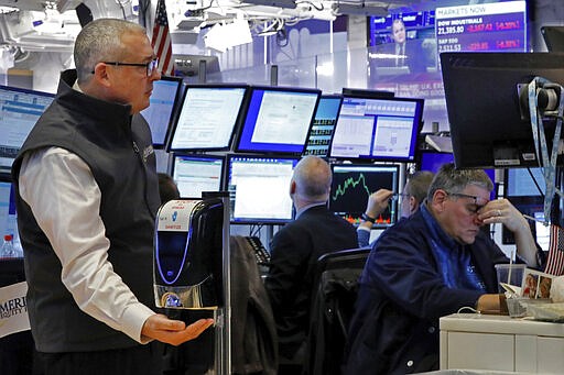 A trader uses a hand sanitizer dispenser on the floor of the New York Stock Exchange, Thursday, March 12, 2020. The deepening coronavirus crisis is sending stocks into another alarming slide on Wall Street, triggering a brief, automatic shutdown in trading for the second time this week. (AP Photo/Richard Drew)