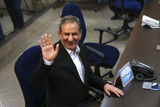 CORRECTS FIRST NAME TO ESHAQ: FILE - In this April 15, 2017 file photo, Iranian Vice-President Eshaq Jahangiri waves to media while registering his candidacy for the May 19, 2017, presidential elections, at the Interior Ministry, in Tehran, Iran. Jahangiri and two other Cabinet members have contracted the new coronavirus, semiofficial Fars News Agency reported Wednesday, March 11, 2020. The vast majority of people recover from the new virus. (AP Photo/Vahid Salemi, File)