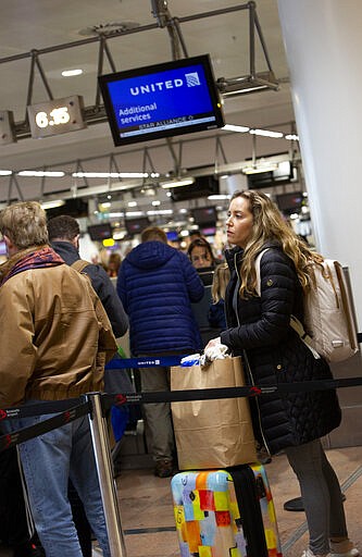 Christine Barto, from Williamsport, Pennsylvania, USA, waits to speak to a representative at the United Airlines counter at Brussels International Airport in Brussels, Thursday, March 12, 2020. The European Union has slammed the new anti-virus travel ban announced by U.S. President Donald Trump on Wednesday. For most people, the new coronavirus causes only mild or moderate symptoms, such as fever and cough. For some, especially older adults and people with existing health problems, it can cause more severe illness, including pneumonia. (AP Photo/Virginia Mayo)