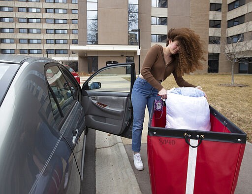 A student moves out of Witte Residence Hall Thursday, March 12, 2020 on the campus of UW-Madison in Madison, Wis. The university is one of multiple Wisconsin universities on Wednesday took dramatic steps to ward off or curb the spread of the COVID-19 outbreak, everything from moving courses online to canceling university-sponsored travel and events to extending spring break. (Mark Hoffman/Milwaukee Journal-Sentinel via AP)