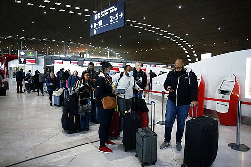Passengers wait in front of the desk of Air France at the Roissy Charles de Gaulle airport, north of Paris, Thursday, March 12, 2020. The European Union on Thursday will evaluate President Donald Trump's decision to restrict travel from Europe to the United States amid deep concern over the economic impact of the move with markets already heavily hit by coronavirus. For most people, the new coronavirus causes only mild or moderate symptoms, such as fever and cough. For some, especially older adults and people with existing health problems, it can cause more severe illness, including pneumonia. (AP Photo/Thibault Camus)
