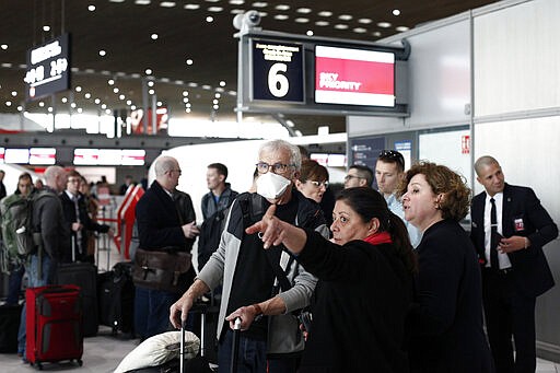 Passengers wait in front of the desk of Air France at the Roissy Charles de Gaulle airport, north of Paris, Thursday, March 12, 2020. The European Union on Thursday will evaluate President Donald Trump's decision to restrict travel from Europe to the United States amid deep concern over the economic impact of the move with markets already heavily hit by coronavirus. For most people, the new coronavirus causes only mild or moderate symptoms, such as fever and cough. For some, especially older adults and people with existing health problems, it can cause more severe illness, including pneumonia. (AP Photo/Thibault Camus)