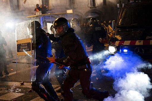 FILE - In this Oct. 26, 2019 file photo, police officers clash with Catalan pro-independence protesters during a demonstration in Barcelona. As 2019 gave way to 2020 in a cloud of tear gas, and in some cases a hail of bullets, from Hong Kong to Baghdad, from Beirut to Barcelona and Santiago, it seemed civil disobedience and government crackdowns on protests would dominate the international landscape. Then came the coronavirus. Protests, by their very nature driven by large gatherings, have been doused. The vast majority of people recover from the new coronavirus. (AP Photo/Felipe Dana, File)