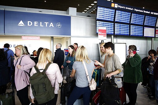 Passengers wait in front of the desk of American airline company 'Delta', at the Roissy Charles de Gaulle airport, north of Paris, Thursday, March 12, 2020. The European Union on Thursday will evaluate President Donald Trump's decision to restrict travel from Europe to the United States amid deep concern over the economic impact of the move with markets already heavily hit by coronavirus. For most people, the new coronavirus causes only mild or moderate symptoms, such as fever and cough. For some, especially older adults and people with existing health problems, it can cause more severe illness, including pneumonia. (AP Photo/Thibault Camus)