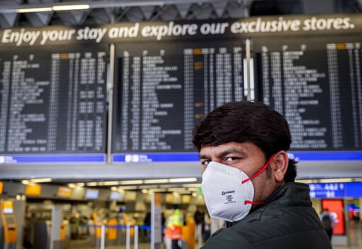 A passenger from India waits for his flight in a terminal at the airport in Frankfurt, Germany, Thursday, March 12, 2020. For most people, the new coronavirus causes only mild or moderate symptoms, such as fever and cough. For some, especially older adults and people with existing health problems, it can cause more severe illness, including pneumonia. (AP Photo/Michael Probst)