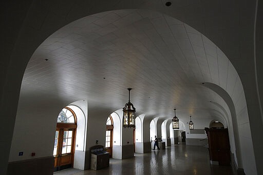 A man walks toward an exit in an empty area in front of the Wheeler Hall auditorium on the University of California campus in Berkeley, Calif., Wednesday, March 11, 2020. UC Berkeley has suspended in-person classes because of the coronavirus. (AP Photo/Jeff Chiu)