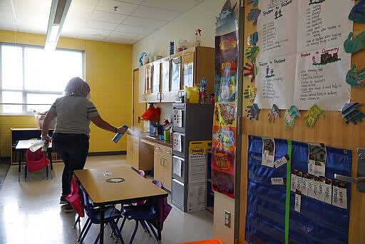 Fort Worth ISD employee Yolanda Cintron assists with a deep cleaning at the Leadership Academy at John T. White Elementary School in Fort Worth, Texas on Thursday, March 12, 2020. (Lawrence Jenkins/The Dallas Morning News via AP)