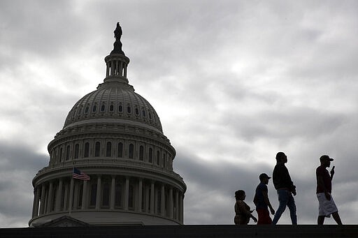 Visitors walk past the U.S. Capitol dome on Capitol Hill in Washington, Thursday, March 12, 2020. Congress is shutting the Capitol and all House and Senate office buildings to the public until April in reaction to the spread of the coronavirus outbreak. (AP Photo/Patrick Semansky)