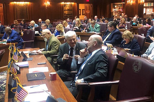 Rep. Ed Soliday, R-Valparaiso, center, speaks with former Indiana House Speaker Brian Bosma, R-Indianapolis, during a House session on Wednesday, March 11, 2020, at the Statehouse in Indianapolis. Lawmakers were expected to adjourn this year's legislative session on Wednesday. (AP Photo/Tom Davies)