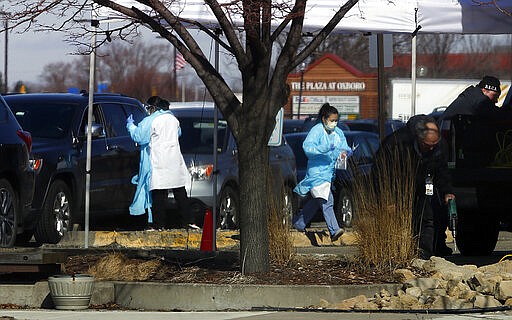 Medical staff wearing safety garments assist drivers at a new coronavirus drive-up test clinic, one of several in the metropolitan Twin Cities area, Friday, March 13, 2020, in Bloomington, Minn. The vast majority of people recover from the new coronavirus. According to the World Health Organization, most people recover in about two to six weeks, depending on the severity of the illness. (AP Photo/Jim Mone)