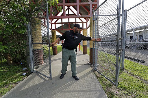 School Resource Officer Donald Lee locks the gates of the Dr. Martin Luther King, Jr. Elementary School for Science and Technology, after all the students left, in New Orleans, Friday, March 13, 2020. Louisiana Gov. John Bel Edwards on Friday closed K-12 public schools across the state for roughly a month and banned gatherings of more than 250 people in an effort to slow the spread of the coronavirus. For most people, the new coronavirus causes only mild or moderate symptoms. For some it can cause more severe illness. (AP Photo/Gerald Herbert)