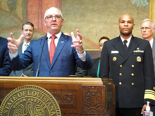 Louisiana Gov. John Bel Edwards speaks about the new coronavirus while U.S. Surgeon General Jerome Adams, right, listens on Thursday, March 12, 2020, in Baton Rouge, La. The number of cases of the COVID-19 disease caused by the virus are on the rise in Louisiana. (AP Photo/Melinda Deslatte)