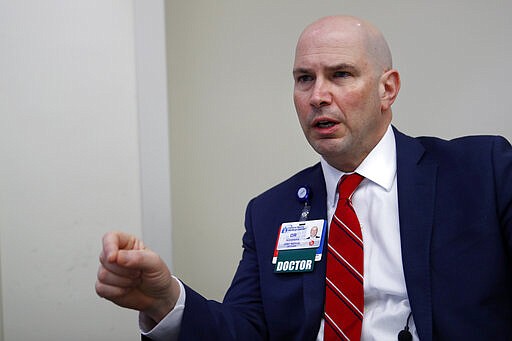 Dr. John Alexander, chief medical officer at Central Maine Healthcare, speaks to a reporter about the hospital's efforts to test patients for the coronavirus, Friday, March 13, 2020, in Lewiston, Maine. U.S. hospitals are setting up circus-like triage tents, calling doctors out of retirement, guarding their supplies of face masks and making plans to cancel elective surgery as they brace for an expected onslaught of coronavirus patients. (AP Photo/Robert F. Bukaty)