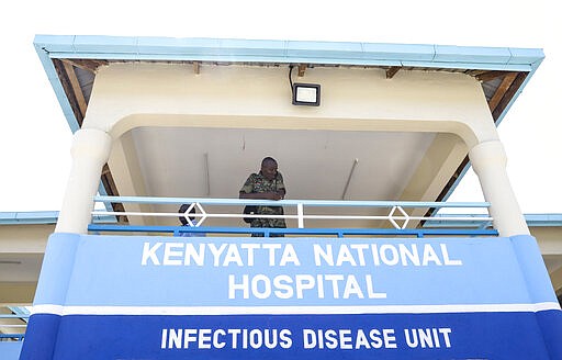 FILE - In this Friday, March 6, 2020 file photo, a member of the Kenyan military looks out from the balcony of the infectious disease unit of Kenyatta National Hospital, to be used to isolate and treat coronavirus cases, located at Mbagathi Hospital, in the capital Nairobi, Kenya. Authorities in Kenya said Friday, March 13, 2020 that a Kenyan woman who recently traveled from the United States via London has tested positive for the new COVID-19 coronavirus, the first case in the East African country. For most people, the new coronavirus causes only mild or moderate symptoms, such as fever and cough. For some, especially older adults and people with existing health problems, it can cause more severe illness, including pneumonia. (AP Photo/Patrick Ngugi, File)