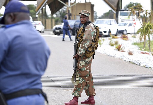 A soldier guards the entrance, Friday, March 13, 2020, to the venue where repatriated South Africans from Wuhan China will be held in quarantine near Polokwane, South Africa. For most people the new coronavirus causes only mild or moderate symptoms, such as fever and cough. For some, especially older adults and people with existing health problems, it can cause more severe illness, including pneumonia. (AP Photo)