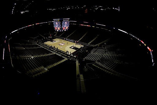 Big 12 commissioner Bob Bowlsby is seen on the big screen in an empty Sprint Center as he talks to the media after canceling the remaining NCAA college basketball games in the Big 12 Conference tournament due to concerns about the coronavirus Thursday, March 12, 2020, in Kansas City, Mo. (AP Photo/Charlie Riedel)