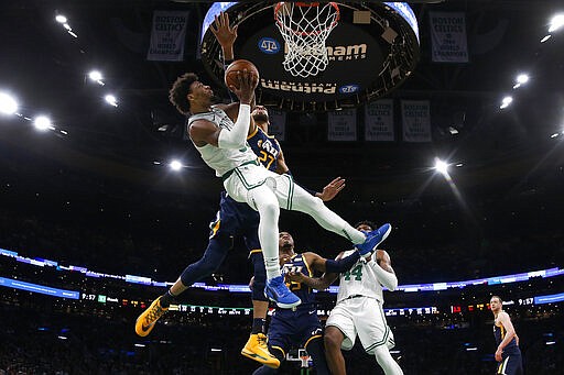 Boston Celtics' Marcus Smart is knocked off balance while going for a shot against Utah Jazz's Rudy Gobert (27) during the fourth quarter of an NBA basketball game Friday, March 6, 2020, in Boston. (AP Photo/Winslow Townson)