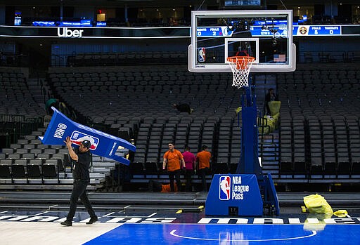 Crews break down the court after the Dallas Mavericks defeated the Denver Nuggets in an NBA basketball game on Wednesday, March 11, 2020 at American Airlines Center in Dallas. The NBA has suspended its season &#147;until further notice&quot; after a Utah Jazz player tested positive Wednesday for the coronavirus, a move that came only hours after the majority of the league's owners were leaning toward playing games without fans in arenas. The vast majority of people recover from the new coronavirus. According to the World Health Organization, most people recover in about two to six weeks, depending on the severity of the illness.  (Ashley Landis /The Dallas Morning News via AP)