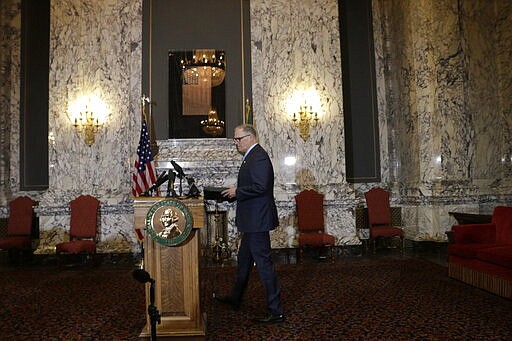 Gov. Jay Inslee walks to a podium to announce the expansion of school closures and prohibition of large gatherings across all of Washington in an effort to slow the spread of the new coronavirus, Friday, March 13, 2020. Inslee issued the executive orders, saying the virus is spreading rapidly across the state. Previously, school closures and prohibitions of large gatherings had only been ordered in the three counties with the highest numbers of cases. (AP Photo/Rachel La Corte)