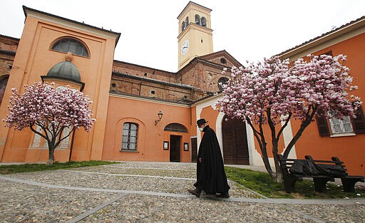 A priest walks in Codogno, Italy, Thursday, March 12, 2020. The Lombardy cluster of COVID-19 was first registered in the tiny town of Codogno on Feb. 19, when the first patient tested positive and has been a red zone until the end of seclusion and return of production in the recent days. For most people, the new coronavirus causes only mild or moderate symptoms, such as fever and cough. For some, especially older adults and people with existing health problems, it can cause more severe illness, including pneumonia. (AP Photo/Antonio Calanni)