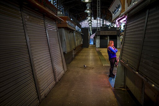 A customer buy meat at the market of La Boqueria in Barcelona, Spain, Thursday, March 12, 2020. Spain's Ibex 35, the benchmark stock market index, registered it's worst day in 28 years of trading Thursday with stocks dropping by 14.06 percent as jitters over the economic impact of the virus outbreak intensified. For most people, the new coronavirus causes only mild or moderate symptoms, such as fever and cough. For some, especially older adults and people with existing health problems, it can cause more severe illness, including pneumonia. (AP Photo/Emilio Morenatti)