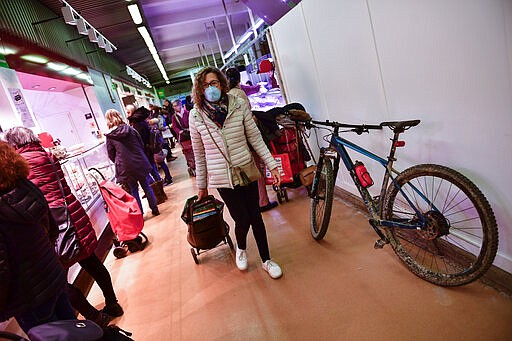 A customer wears a market at a market in Pamplona, northern Spain, Friday, March 13, 2020. For most people, the new COVID-19 coronavirus causes only mild or moderate symptoms, such as fever and cough, but for some, especially older adults and people with existing health problems, it can cause more severe illness, including pneumonia. (AP Photo/Alvaro Barrientos)