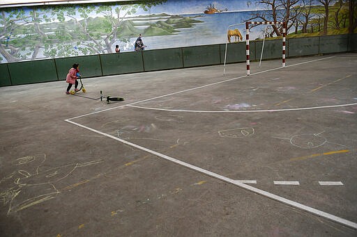 A young girl plays in an empty playground of a public school, in Pamplona, northern Spain, Friday, March 13, 2020. For most people, the new COVID-19 coronavirus causes only mild or moderate symptoms, such as fever and cough, but for some, especially older adults and people with existing health problems, it can cause more severe illness, including pneumonia. (AP Photo/Alvaro Barrientos)