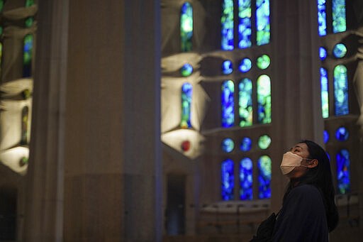 A tourists wearing a face mask, visits the Sagrada Familia basilica in Barcelona, Spain, Thursday, March 12, 2020. The basilica announced it will close its doors to visitors and suspend construction from Friday March 13 to prevent the spread of the new COVID-19 coronavirus. Spain, along with Italy and France, is among the countries worst hit by the virus so far in Europe. For most people, the new coronavirus causes only mild or moderate symptoms, such as fever and cough. For some, especially older adults and people with existing health problems, it can cause more severe illness, including pneumonia. (AP Photo/Renata Brito)