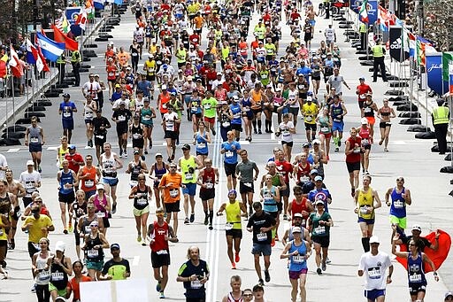 FILE - In this April 17, 2017, runners  in the 121st Boston Marathon head down the stretch to the finish line in Boston. The 124th Boston Marathon is scheduled for Monday, April 20, 2020. Boston Marathon organizers say they're postponing the prestigious race until Sept. 14 because of concerns over the coronavirus pandemic. (AP Photo/Charles Krupa, File)