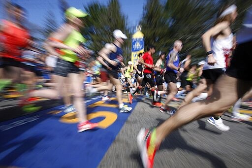 FILE - In this April 17, 2017, file photo, runners cross the Boston Marathon start line in Hopkinton, Mass. The 124th Boston Marathon is scheduled for Monday, April 20, 2020. Boston Marathon organizers say they're postponing the prestigious race until Sept. 14 because of concerns over the coronavirus pandemic. (AP Photo/Mary Schwalm, File)