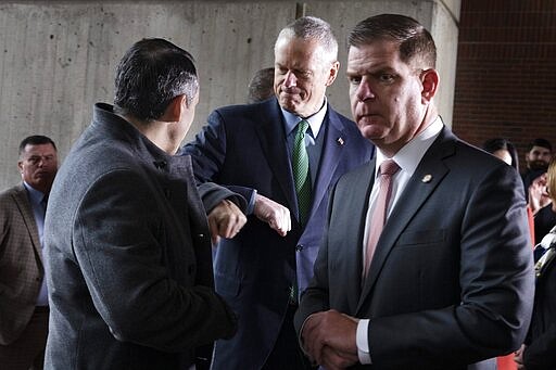 Massachusetts Gov. Charlie Baker, center, bumps elbows with state Rep. Aaron Michlewitz, left, behind Boston Mayor Marty Walsh, right, following a news conference announcing the postponement of the Boston Marathon, Friday, March, 13, 2020, in Boston. The Marathon, which was due to be run on April 20,  will be run on Monday, Sept. 14, 2020, due to concerns about the coronavirus. For most people, the new coronavirus causes only mild or moderate symptoms, such as fever and cough. For some, especially older adults and people with existing health problems, it can cause more severe illness, including pneumonia. The vast majority of people recover from the new virus. (AP Photo/Michael Dwyer)