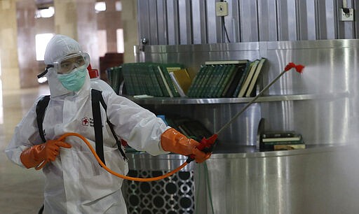 An official sprays disinfectant in the wake of the new coronavirus outbreak at Istiglal mosque in Jakarta, Indonesia, Friday, March 13, 2020. For most people the new coronavirus causes only mild or moderate symptoms, such as fever and cough. For some, especially older adults and people with existing health problems, it can cause more severe illness including pneumonia. (AP Photo/Achmad Ibrahim)