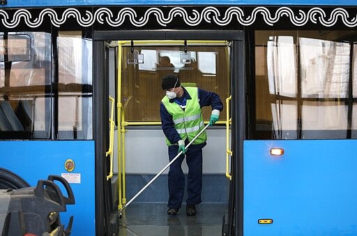 A bus depot employee disinfects a bus in Moscow, Russia, Friday, March 13, 2020.  For most people, the new coronavirus causes only mild or moderate symptoms, such as fever and cough. For some, especially older adults and people with existing health problems, it can cause more severe illness, including pneumonia. (Kirill Zykov, Moscow News Agency photo via AP)