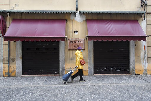 A woman walks in Codogno, Italy, Thursday, March 12, 2020. The northern Italian town that recorded Italy&#146;s first coronavirus infection has offered a virtuous example to fellow Italians, now facing an unprecedented nationwide lockdown, that by staying home, trends can reverse. Infections of the new virus have not stopped in Codogno, which still has registered the most of any of the 10 Lombardy towns Italy&#146;s original red zone, but they have slowed. For most people, the new coronavirus causes only mild or moderate symptoms. For some it can cause more severe illness. (AP Photo/Antonio Calanni)