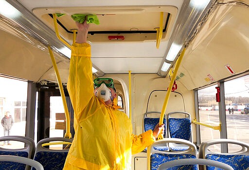 In this photo taken on Thursday, March 12, 2020, A bus depot employee disinfects a bus in Moscow, Russia. For most people, the new COVID-19 coronavirus causes only mild or moderate symptoms, such as fever and cough. For some, especially older adults and people with existing health problems, it can cause more severe illness, including pneumonia. (Denis Voronin, Moscow News Agency photo via AP)