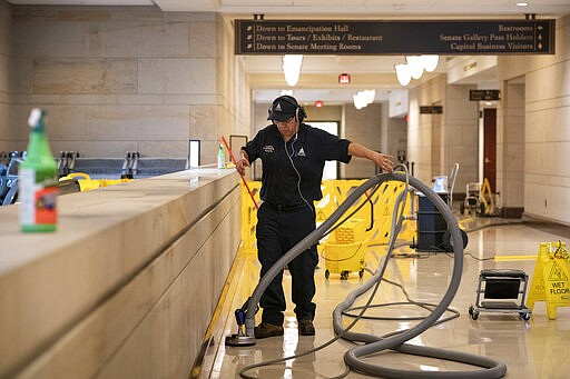 With the Capitol shut down to tourists, a workman performs a routine cleaning of surfaces in the Capitol Visitor Center, early Friday, March 13, 2020, in Washington. (AP Photo/J. Scott Applewhite)